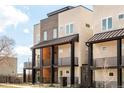 Modern townhome showcasing balconies with black railings, light stucco, and brick accents at 2105 S Galapago St # 4, Denver, CO 80223