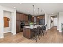 Charming kitchen features an island with pendant lights, wood cabinets, and stainless steel appliances at 3214 Heron Lakes Pkwy, Berthoud, CO 80513