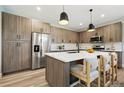 Modern kitchen boasts stainless steel appliances, a large island, and stylish pendant lighting at 4127 Tejon St, Denver, CO 80211