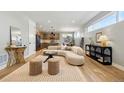Bright living room featuring a curved sofa, woven stools, and views of the modern kitchen at 4127 Tejon St, Denver, CO 80211