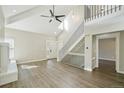 Bright living area with high ceilings, a modern staircase, wood flooring, and a painted brick fireplace at 9455 W 81St Ave # A, Arvada, CO 80005