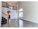 Bright and airy living room featuring hardwood floors, a high ceiling, and a staircase at 10486 Cheetah Winds, Lone Tree, CO 80124