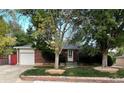 Attractive brick home with mature trees, a garage, and a well-kept lawn at 6140 Depew St, Arvada, CO 80003