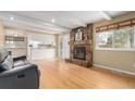 Bright living room featuring hardwood floors, a stone fireplace, and seamless flow to the kitchen at 8970 Garland Ct, Westminster, CO 80021
