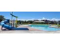 Community pool with a waterslide and plenty of lounge chairs at 4640 Windmill Dr, Brighton, CO 80601