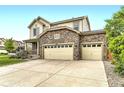 Charming two-story home featuring a stone facade and a spacious three-car garage at 6108 S Harvest Ct, Aurora, CO 80016