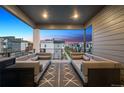 Spacious covered balcony with comfortable seating, offering neighborhood views and outdoor living space at 12270 W 57Th Ave, Arvada, CO 80002