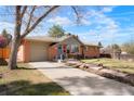 Angle view of brick home featuring an attached garage, concrete driveway and well-manicured lawn at 8276 E Easter Pl, Centennial, CO 80112