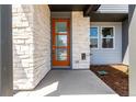 Close-up of front door with modern design and stone exterior at 5783 N Jericho Way, Aurora, CO 80019