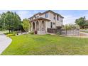 View of the two-story home with a large green lawn at 10559 Sedalia St, Commerce City, CO 80022