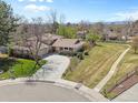 Spacious home boasting a long driveway, beautiful landscaping, and a well-maintained yard at 6490 S Pontiac Ct, Centennial, CO 80111