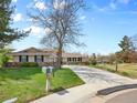 Lovely home with a long driveway, mature trees, and a well-maintained lawn on a sunny day at 6490 S Pontiac Ct, Centennial, CO 80111