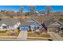 Aerial view of a blue home with a two-car garage, gray roof, and manicured lawn in a neighborhood at 12957 W 78Th Cir, Arvada, CO 80005