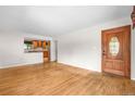 Inviting living room with gleaming hardwood floors and a classic solid wood front door at 7742 W Florida Dr, Lakewood, CO 80232