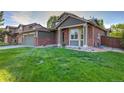 Beautiful home with green lawn, brick and siding exterior, and attached garage, situated in a residential neighborhood at 2587 S Flanders Ct, Aurora, CO 80013