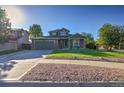 Traditional two-story home featuring a well-maintained lawn, rock landscaping, and an attached two-car garage at 2587 S Flanders Ct, Aurora, CO 80013