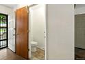 Entryway with access to a powder room with tile flooring, wooden door, and view to the outside at 6376 Lamar Pl, Arvada, CO 80003