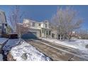 Two-story house with a driveway, surrounded by snow-covered trees at 2959 Skyward Way, Castle Rock, CO 80109