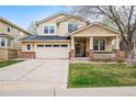 Inviting two-story home featuring a covered porch, brick accents, and a well-manicured lawn at 5049 Heatherglen Dr, Highlands Ranch, CO 80130