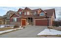 Two-story house with brown siding, brick accents, and a two-car garage at 4067 S Odessa St, Aurora, CO 80013