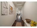 Bright entryway with hardwood floors, decorative wall art, and an inviting view into the home's living spaces at 848 Sandstone Cir, Erie, CO 80516