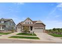 Charming two-story home with a three-car garage, landscaped yard, and craftsman style front door at 848 Sandstone Cir, Erie, CO 80516