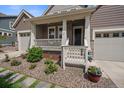 Close up of the entrance with front porch, landscaped yard, and craftsman-style front door at 848 Sandstone Cir, Erie, CO 80516
