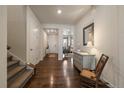 Inviting entryway with hardwood floors, stairs, and vintage-style dresser with mirror at 848 Sandstone Cir, Erie, CO 80516