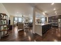 Open-concept living space with hardwood floors, abundant natural light, and seamless kitchen access at 848 Sandstone Cir, Erie, CO 80516