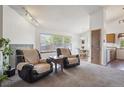 Comfortable living room featuring large windows, and an open floor plan leading to the kitchen and dining area at 11337 E 1St Ave, Aurora, CO 80010