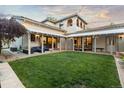 Spacious backyard featuring a lush lawn, covered patio, and charming string lights at 4525 King St, Denver, CO 80211