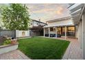 Lush backyard featuring a water feature, string lights, brick patio, and plenty of room to relax at 4525 King St, Denver, CO 80211