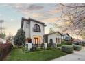 Elegant two-story home with manicured lawn, mature landscaping, and wrought iron fencing at 4525 King St, Denver, CO 80211