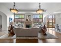 Bright living room with large windows, stone fireplace, hardwood floors, and stylish chandeliers at 4525 King St, Denver, CO 80211
