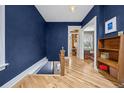 Elegant hallway with hardwood floors, deep blue walls, and intricate trim details at 1243 N Lafayette St, Denver, CO 80218