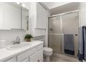 Second bath with a shower and glass door, white vanity and sink, and great light at 3450 S Poplar St # 109, Denver, CO 80224