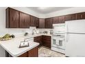 Efficient kitchen with wooden cabinets, white appliances, and ample counter space at 3450 S Poplar St # 109, Denver, CO 80224