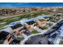 An aerial shot of a neighborhood featuring modern homes, green spaces, and well-planned streets under a partly cloudy sky at 1867 Homestead Dr, Fort Lupton, CO 80621
