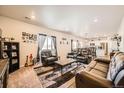 Spacious living room featuring leather sofas, a coffee table, and a view into the kitchen at 1867 Homestead Dr, Fort Lupton, CO 80621