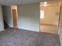 Open living area features neutral walls and carpeting, flowing seamlessly into a kitchen and dining space at 8353 Gaylord St, Denver, CO 80229