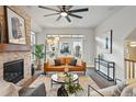 Cozy living room with a stone fireplace, modern furnishings, and a ceiling fan at 15628 W Baker Ave, Lakewood, CO 80228