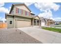 View of a two-story home with two car garage, stone landscaping, and a spacious driveway at 27604 E Byers Ave, Aurora, CO 80018