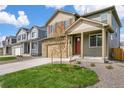 Charming home with a well-maintained lawn, spacious driveway, and inviting red front door at 27604 E Byers Ave, Aurora, CO 80018