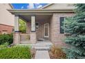 Inviting front porch of a brick home, featuring a cozy entrance at 21063 E Greenwood Pl, Aurora, CO 80013