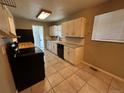 Functional kitchen featuring white cabinets, tiled floors, and modern black appliances at 1836 E Mineral Ave, Centennial, CO 80122