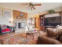 Cozy living room with brick fireplace, ceiling fan, wood floors and stylish furnishings at 470 Mcdonnell St, Byers, CO 80103