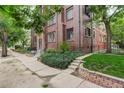 Corner view of a brick building showing the lush landscaping and exterior architecture at 1060 N Washington St # 1A, Denver, CO 80203