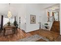 Bright living room with wood floors, a staircase, and a view into the dining room at 6327 S Emporia Cir, Englewood, CO 80111