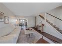 Cozy living room with modern decor, seamlessly connecting to the dining area and stairs at 3738 Miller Ct, Wheat Ridge, CO 80033