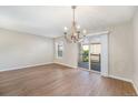 Dining room with hardwood floors, decorative chandelier, and sliding glass doors at 8735 E 29Th Pl, Denver, CO 80238